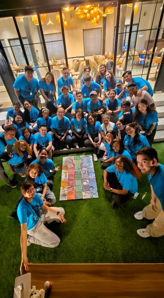 The Koinonia team gathered around a shared piece of art